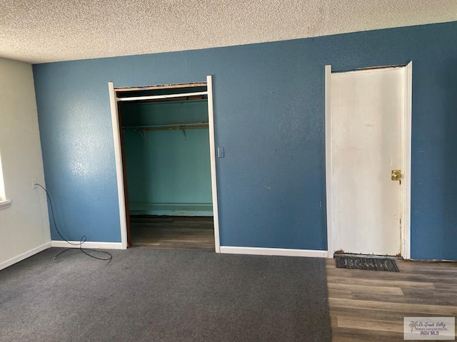 unfurnished bedroom with a closet, dark wood-type flooring, and a textured ceiling