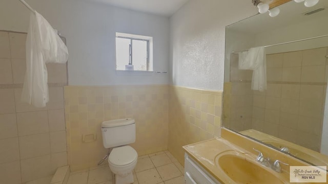 bathroom featuring tile patterned floors, toilet, vanity, tile walls, and a shower with shower curtain