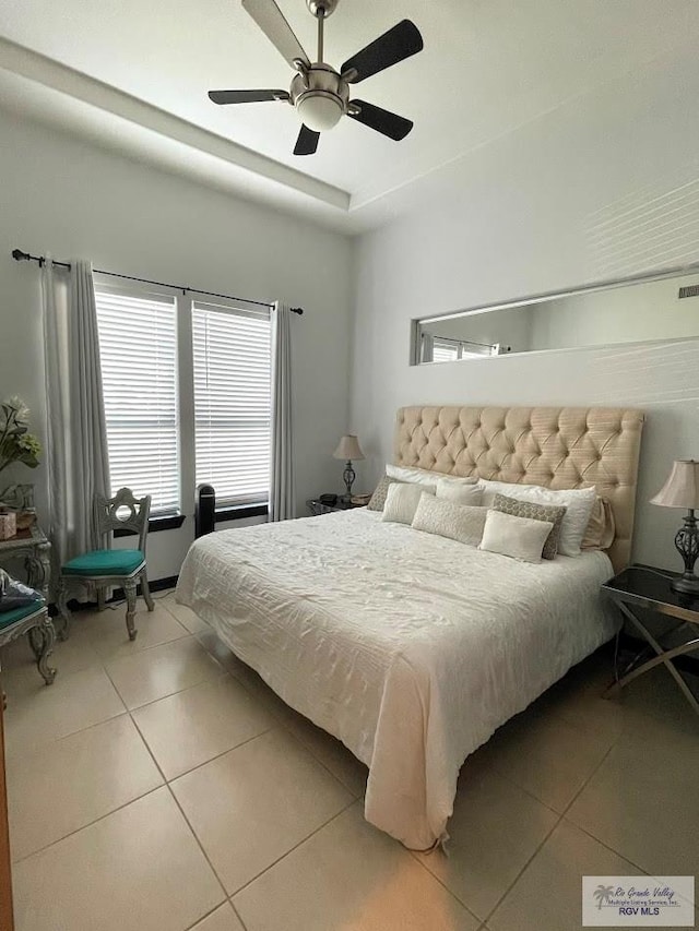 tiled bedroom featuring ceiling fan