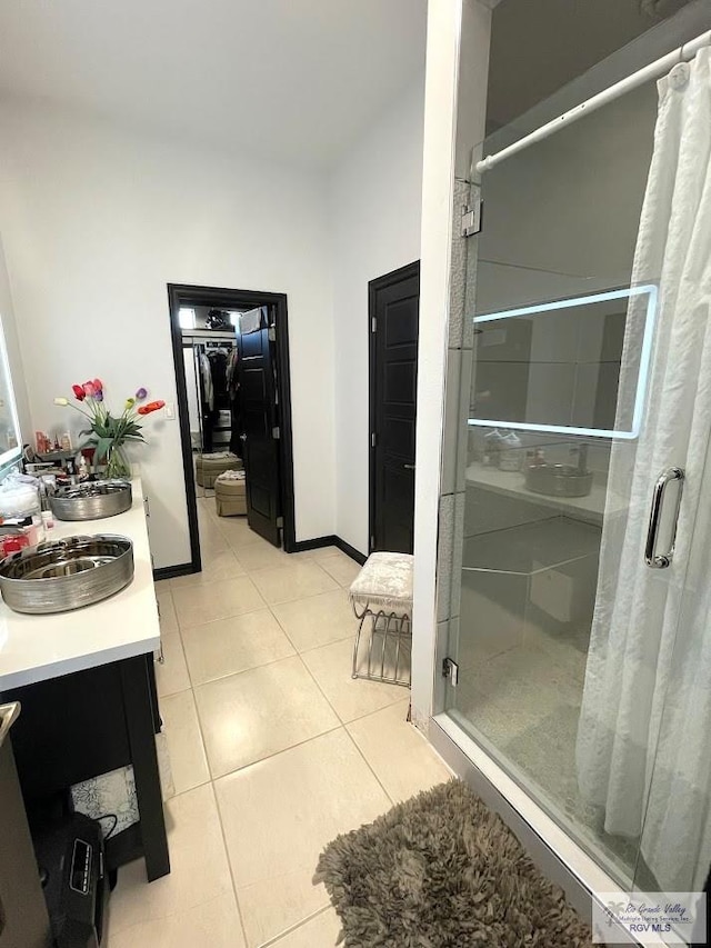 bathroom featuring tile patterned flooring, vanity, and walk in shower