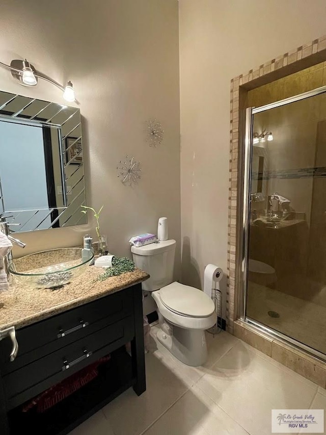 bathroom featuring tile patterned floors, toilet, and a shower with shower door