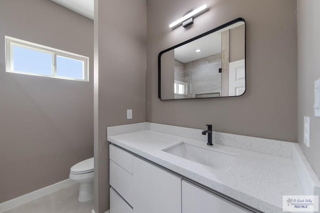 bathroom featuring tile patterned flooring, vanity, toilet, and walk in shower