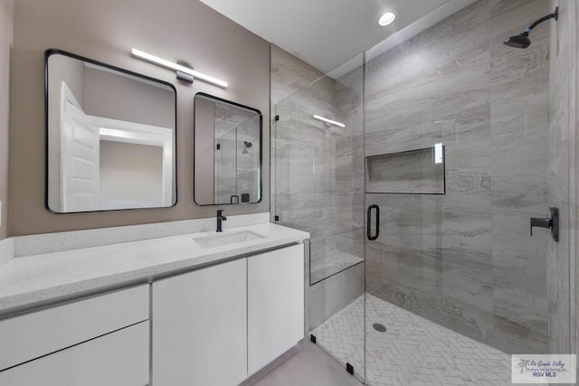 bathroom with vanity and a shower with shower door