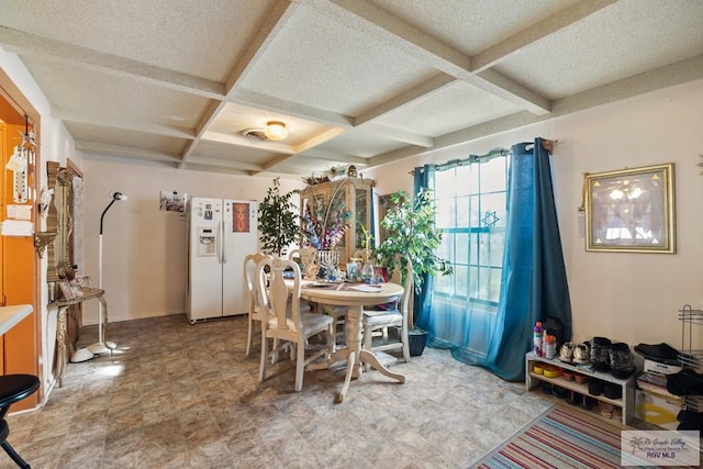 dining space featuring beam ceiling and coffered ceiling