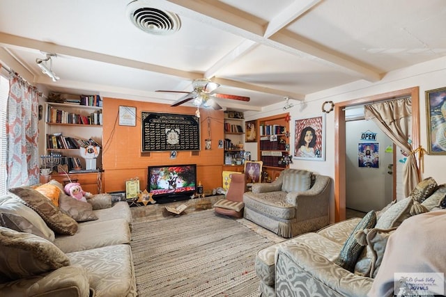 living room featuring beamed ceiling and ceiling fan