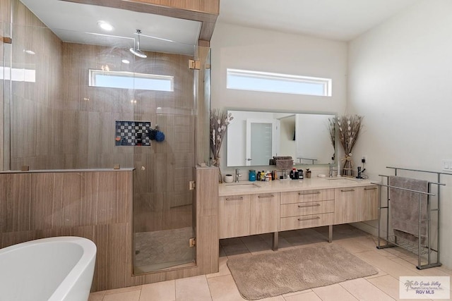 bathroom featuring shower with separate bathtub, vanity, and tile patterned floors