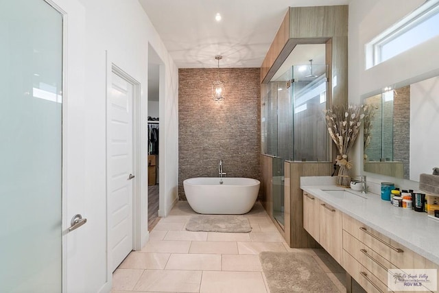 bathroom featuring tile patterned flooring, vanity, independent shower and bath, and tile walls