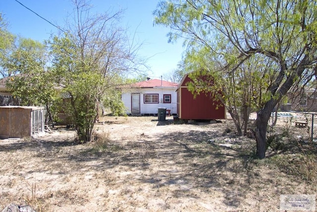 view of yard featuring a storage shed, an outdoor structure, and fence