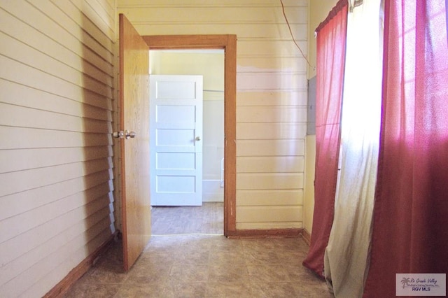 hallway featuring wood walls