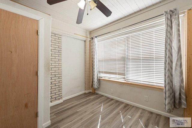 unfurnished bedroom with a closet, ceiling fan, baseboards, and wood finished floors