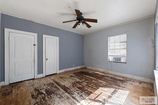 unfurnished bedroom with a ceiling fan, baseboards, cooling unit, and wood finished floors