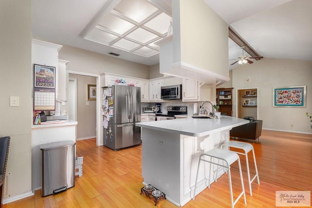 134 Camaguey Ave, Brownsville, TX 78526 - kitchen with appliances with stainless steel finishes, a peninsula, white cabinetry, and light wood-style flooring