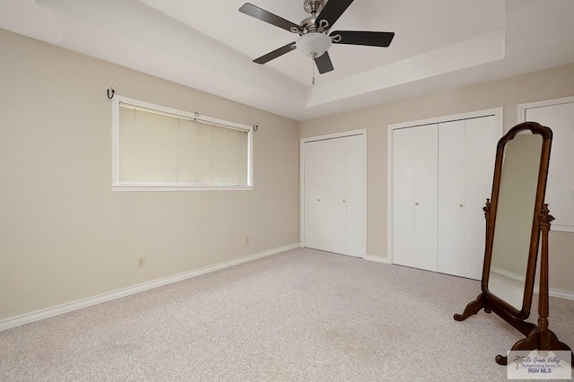 3406 Spyglass Hill Dr, Harlingen, TX 78550 - unfurnished bedroom featuring two closets, carpet flooring, a raised ceiling, and baseboards