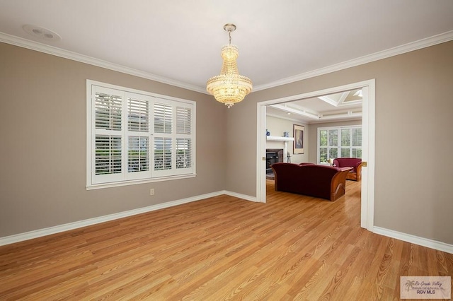 3406 Spyglass Hill Dr, Harlingen, TX 78550 - unfurnished room with ornamental molding, a chandelier, light wood finished floors, baseboards, and a fireplace