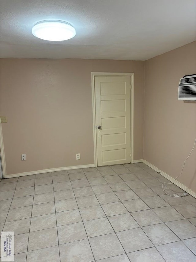 tiled empty room featuring a wall mounted air conditioner