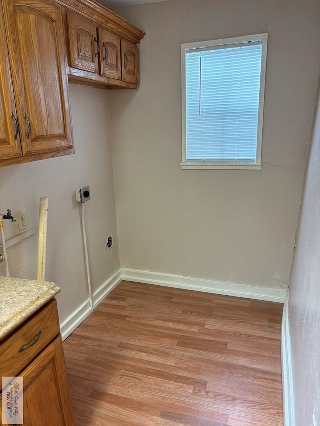 clothes washing area with light hardwood / wood-style floors and electric dryer hookup