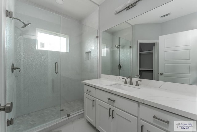 bathroom with vanity and a shower with shower door