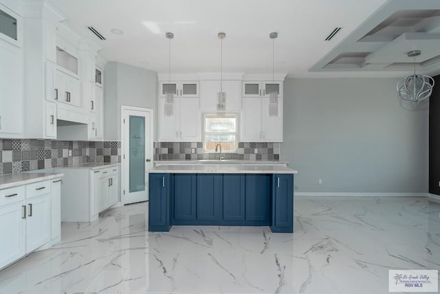 kitchen featuring blue cabinetry, pendant lighting, white cabinetry, and a kitchen island