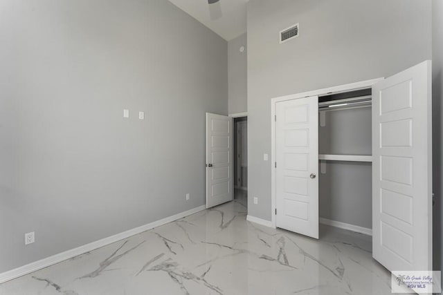 unfurnished bedroom with high vaulted ceiling, a closet, and ceiling fan