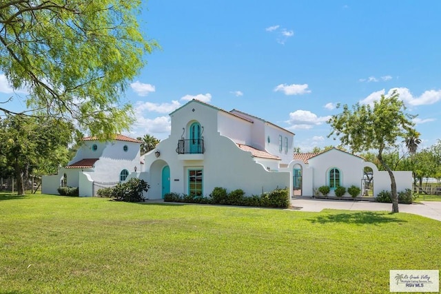 mediterranean / spanish-style house featuring a balcony and a front yard