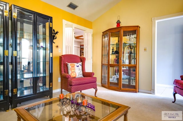 living area featuring carpet flooring and vaulted ceiling