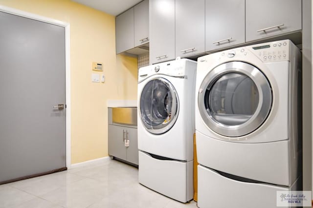 washroom featuring washer and clothes dryer and cabinets