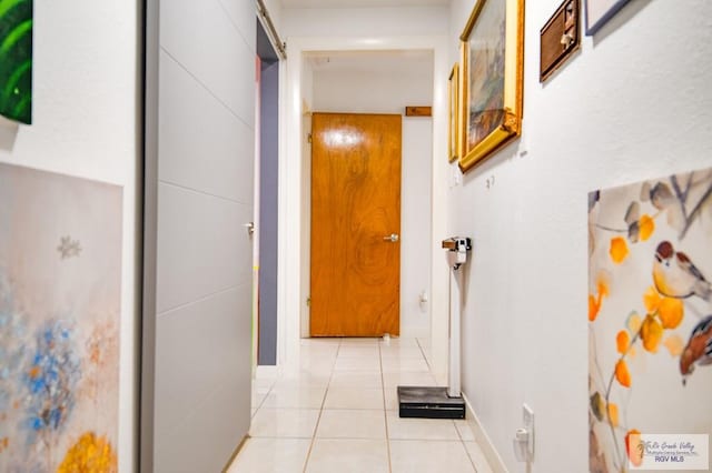 hallway featuring a barn door and light tile patterned flooring