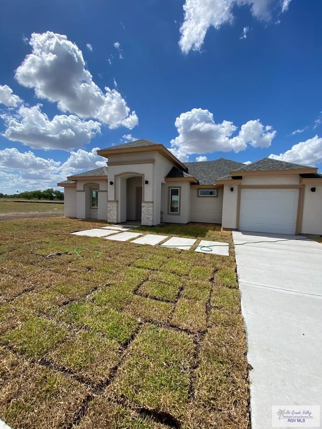 prairie-style home with a garage and a front lawn