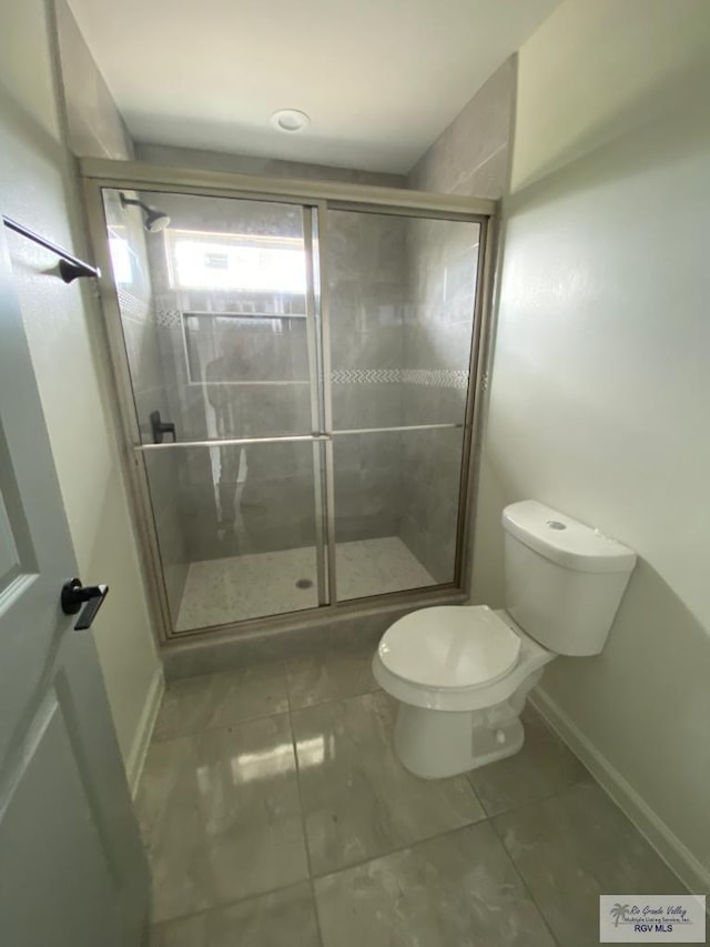 bathroom with tile patterned floors, toilet, and an enclosed shower