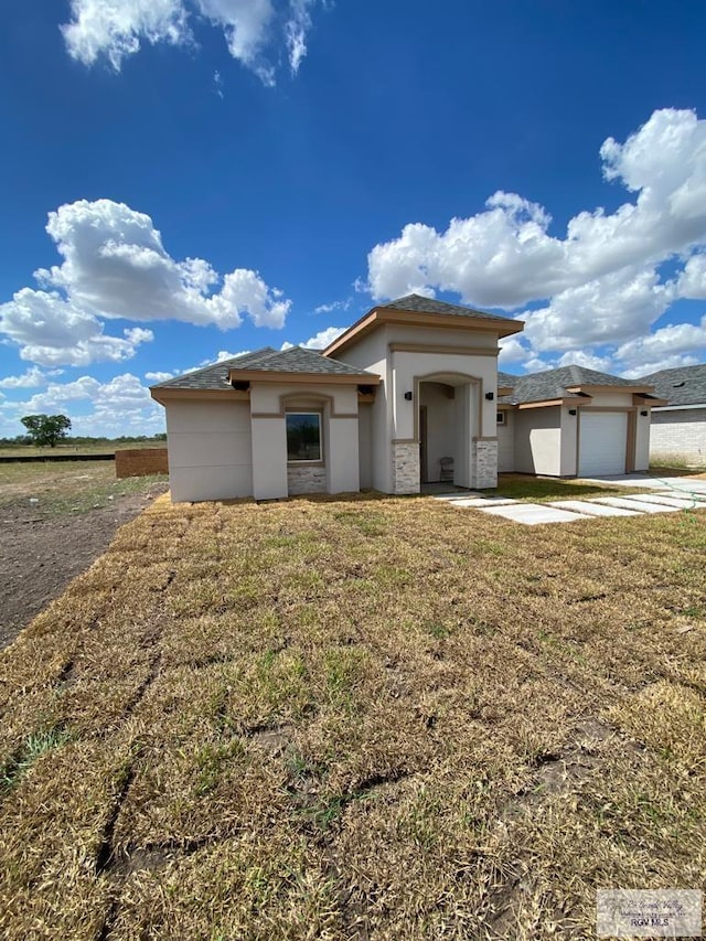 prairie-style house with a garage and a front yard