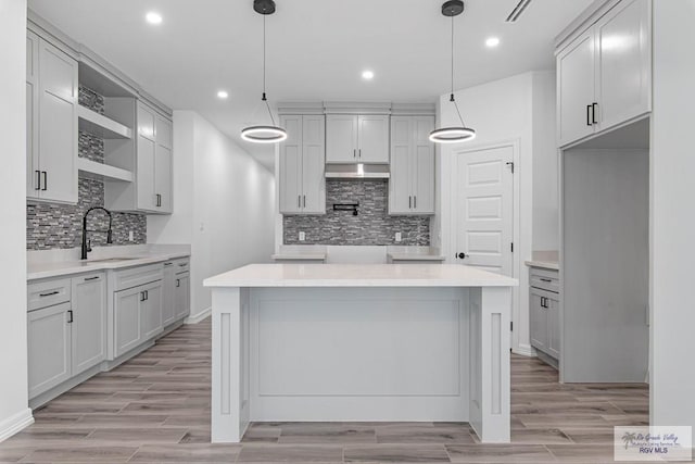 9718 Alexis Ave, Harlingen, TX 78550 - kitchen featuring wood tiled floor, a sink, open shelves, and a kitchen island