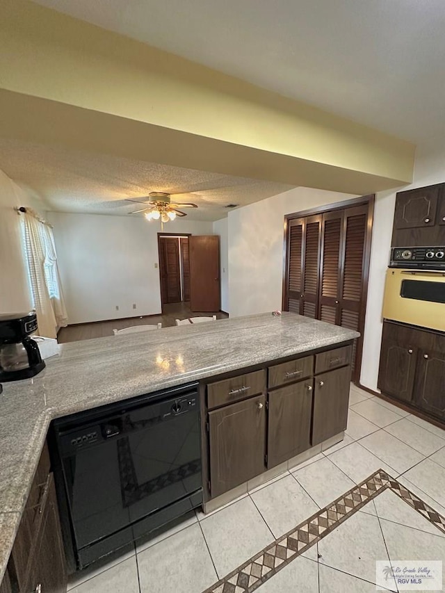 kitchen with light tile patterned flooring, dark brown cabinets, and black appliances