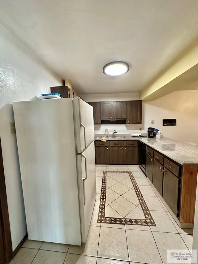 kitchen featuring dishwasher, white refrigerator, sink, dark brown cabinets, and light tile patterned flooring