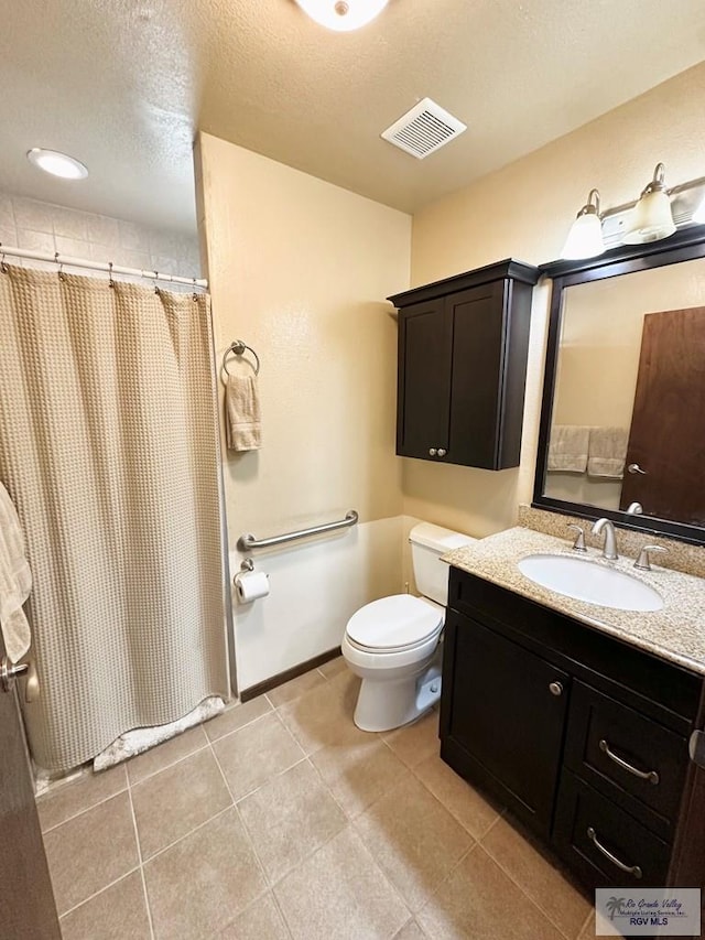 bathroom featuring vanity, tile patterned floors, toilet, a textured ceiling, and curtained shower