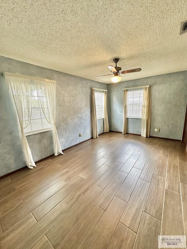 unfurnished room featuring a textured ceiling, light hardwood / wood-style flooring, and ceiling fan