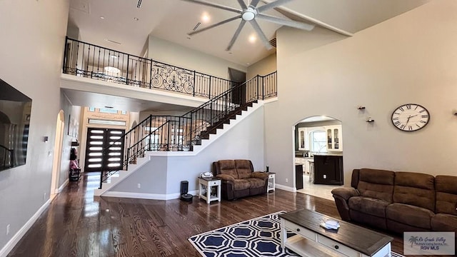 5443 Autumn Mist Ln, Brownsville, TX 78526 - living room featuring arched walkways, ceiling fan, a high ceiling, wood finished floors, and stairs