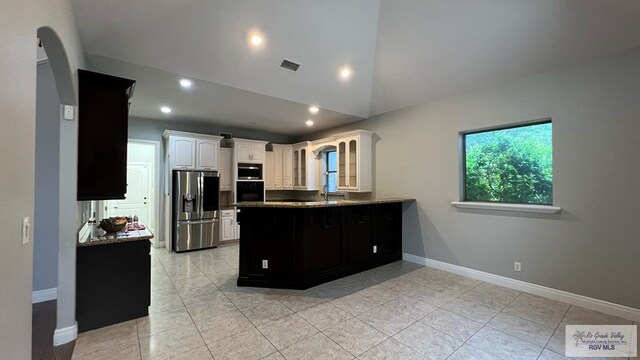5443 Autumn Mist Ln, Brownsville, TX 78526 - kitchen with stainless steel fridge with ice dispenser, black oven, a peninsula, glass insert cabinets, and white cabinetry
