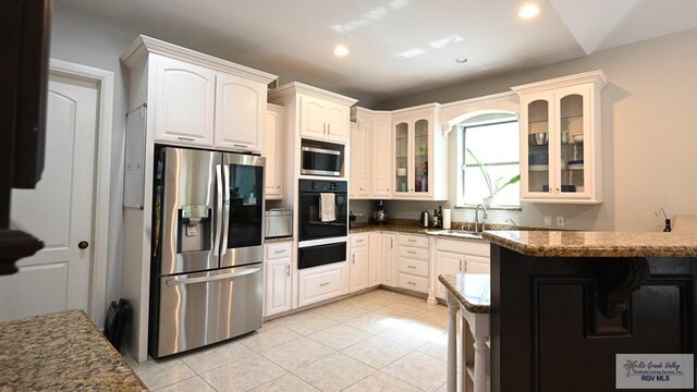 5443 Autumn Mist Ln, Brownsville, TX 78526 - kitchen featuring stainless steel appliances, a warming drawer, glass insert cabinets, recessed lighting, and dark stone counters