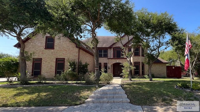 view of front of house with brick siding and a front lawn