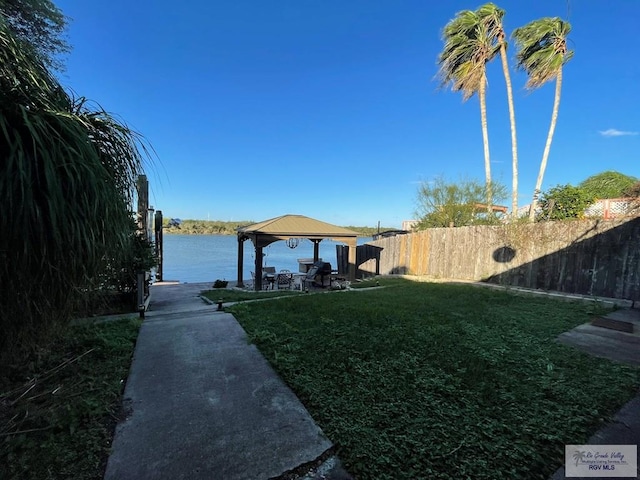 dock area featuring a gazebo, a water view, and a lawn