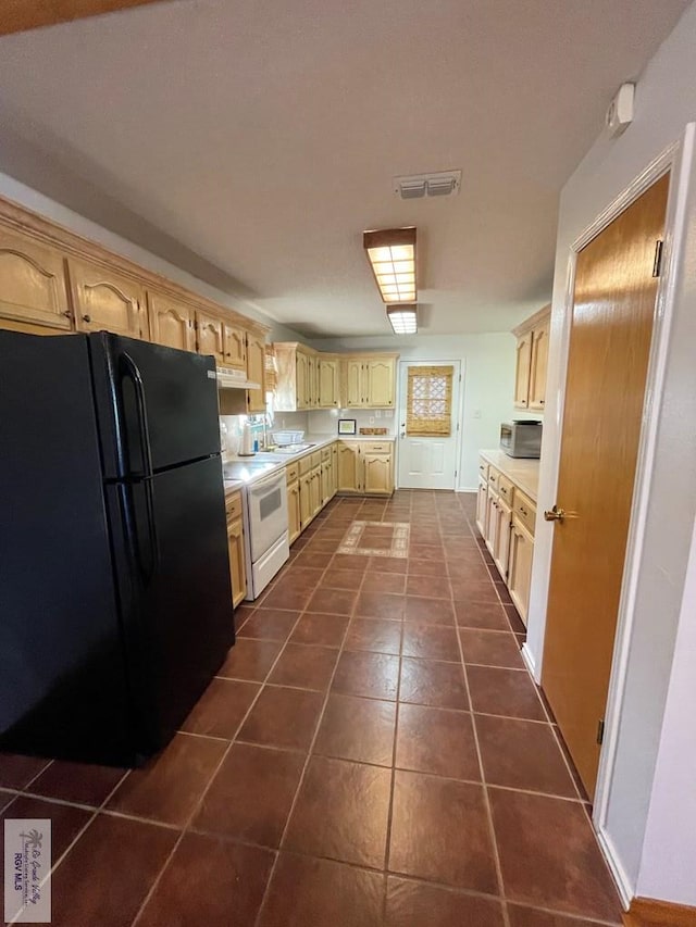 kitchen featuring sink, light brown cabinets, white electric range oven, dark tile patterned floors, and black refrigerator