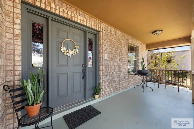 view of exterior entry featuring covered porch