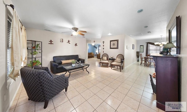 living room featuring ceiling fan with notable chandelier and light tile patterned floors