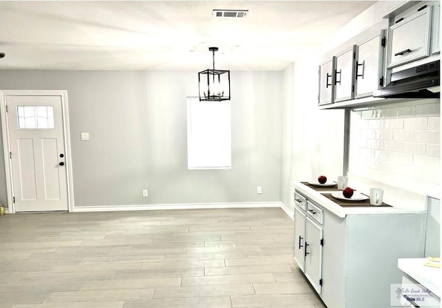 kitchen with decorative backsplash, visible vents, a wealth of natural light, and light wood-type flooring