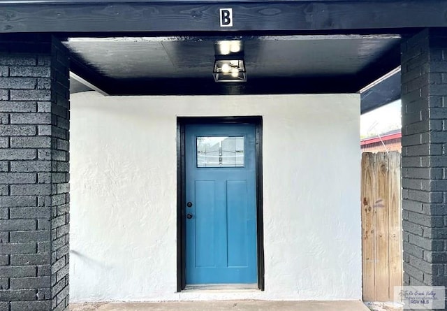 entrance to property featuring stucco siding