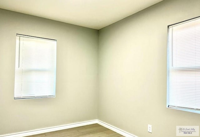 empty room featuring baseboards and wood finished floors