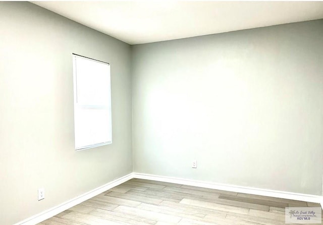 empty room with baseboards and wood finished floors