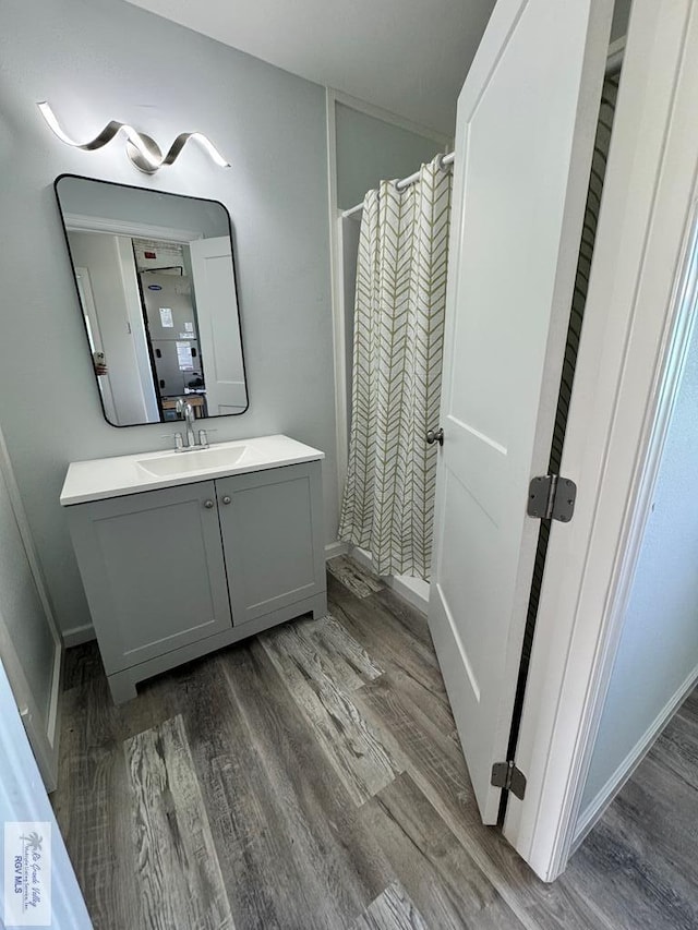 bathroom with hardwood / wood-style floors, a shower with curtain, and vanity