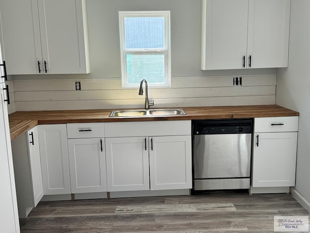 kitchen with butcher block countertops, white cabinets, and stainless steel dishwasher