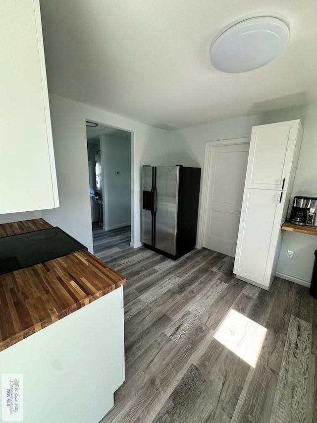 kitchen with wood counters, stainless steel refrigerator with ice dispenser, dark hardwood / wood-style flooring, and white cabinetry